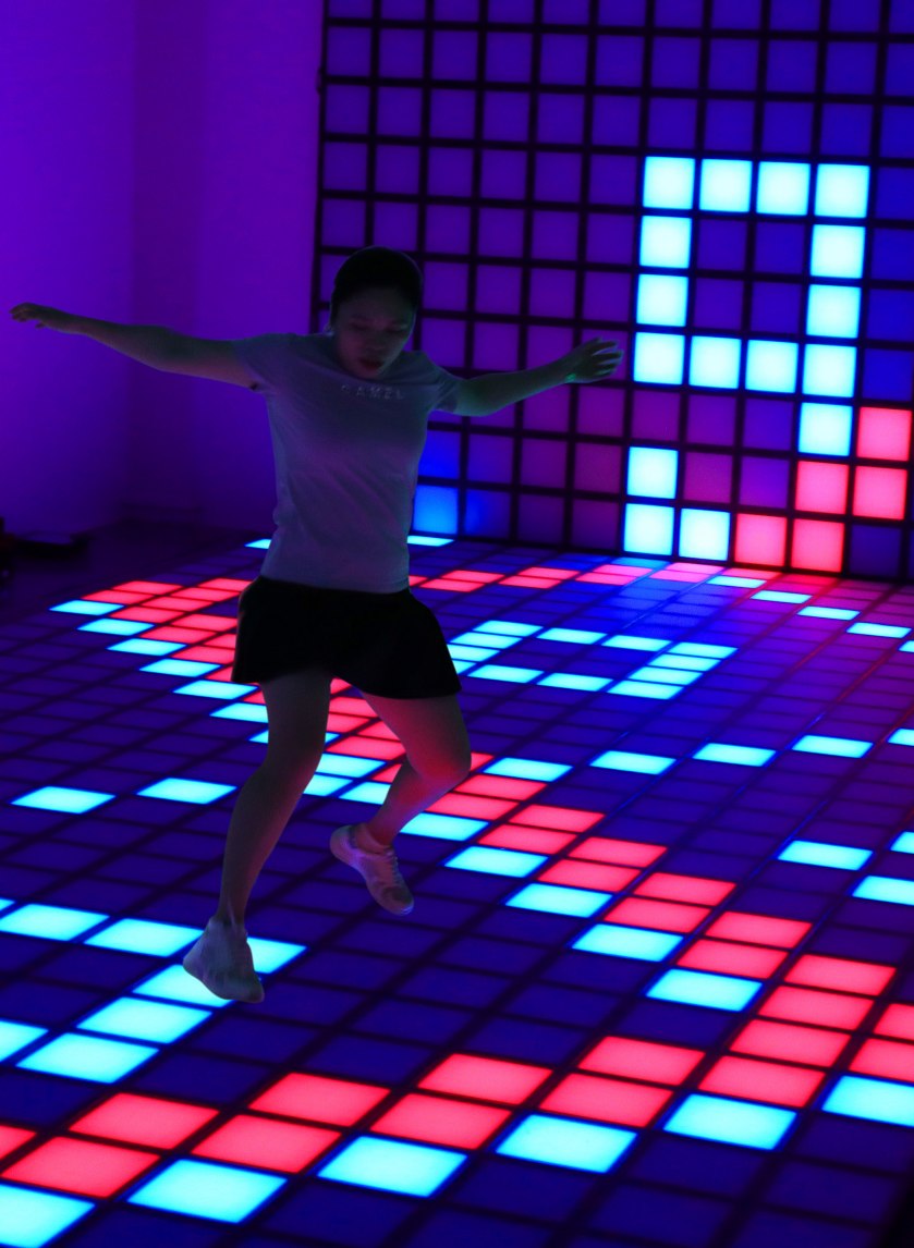 A guest playing on a Playdia interactive LED floor attraction